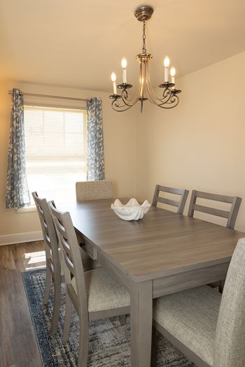 A dining room with a wooden table and chairs.